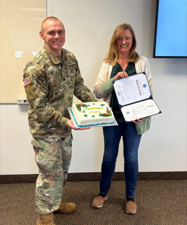 A picture showing Captain Zachary Eich, ProAg Software Engineer III, presenting the ESGR Service Member Patriot Award to Nancy Molter-Zirbes, ProAg Software Development Manager.